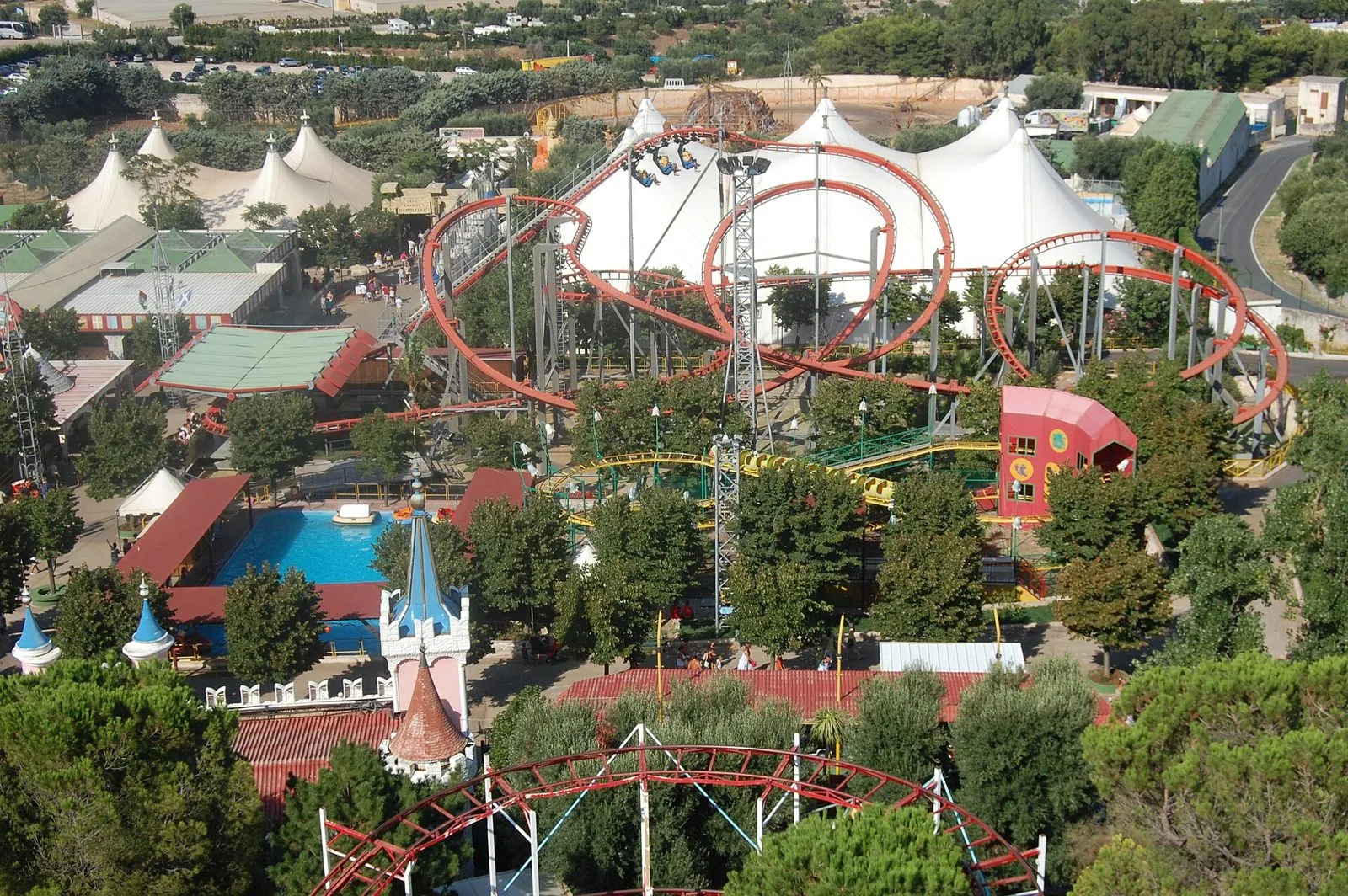 Il parco divertimenti Fasanolandia visto dall'alto, con montagne russe, piscina e tendoni bianchi fra gli alberi